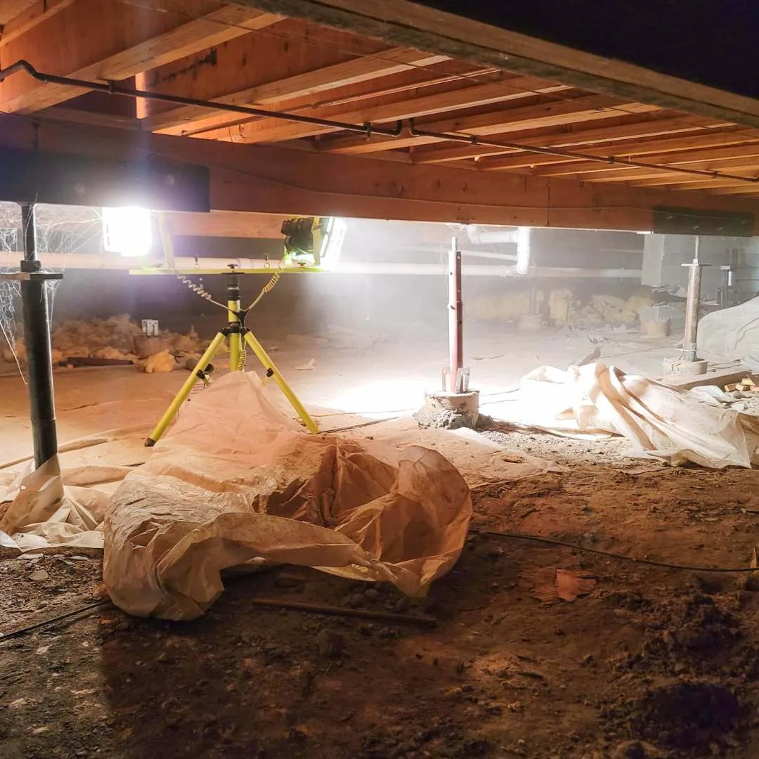 A Jacksonville, FL crawlspace during an inspection, work light on a tripod stand