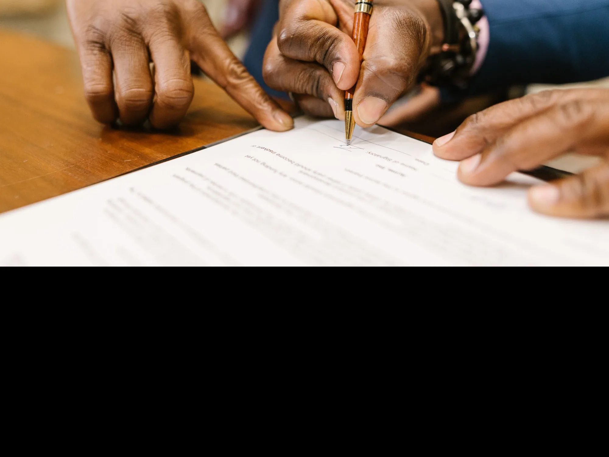 Two people reviewing and pointing to an insurance policy document on a desk
