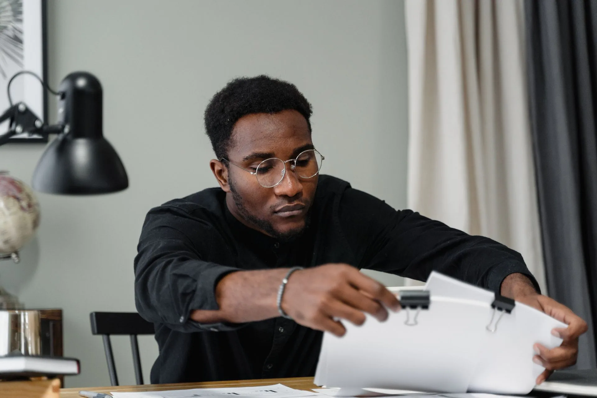 A man reviewing a bound document at a desk