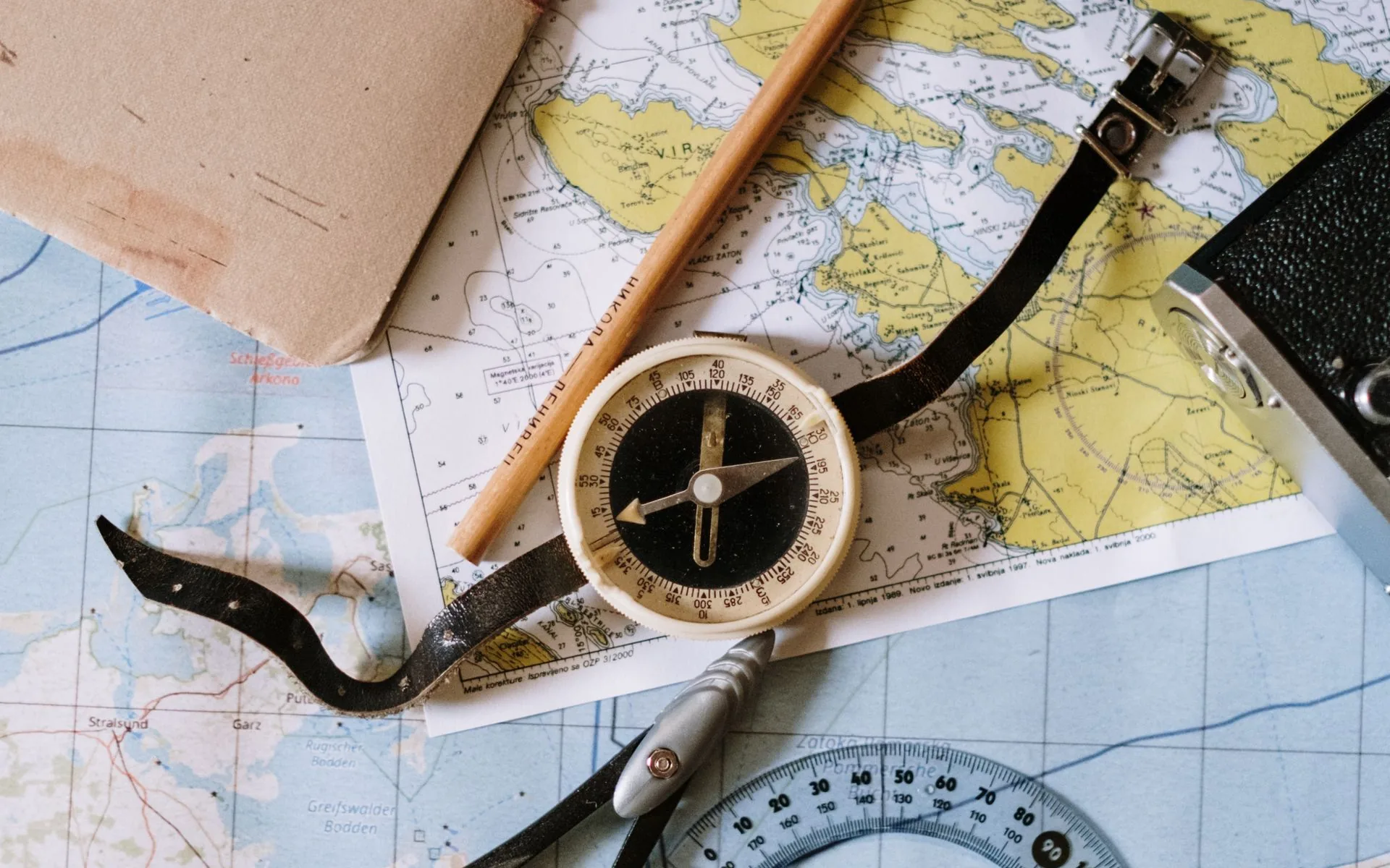 A compass and drafting tools resting on a nautical map