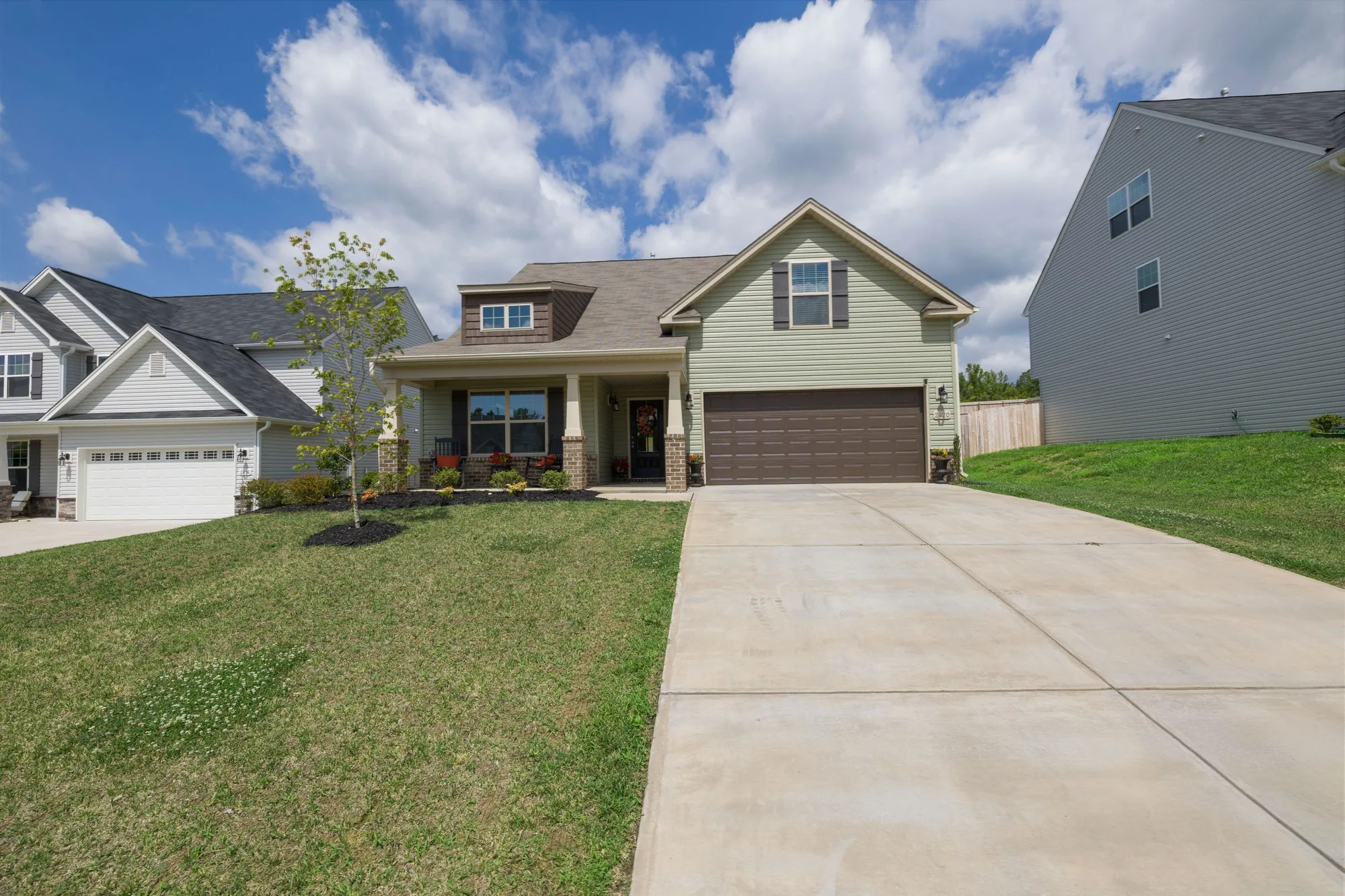 A light blue two-story suburban Florida home with a red front door and a concrete driveway